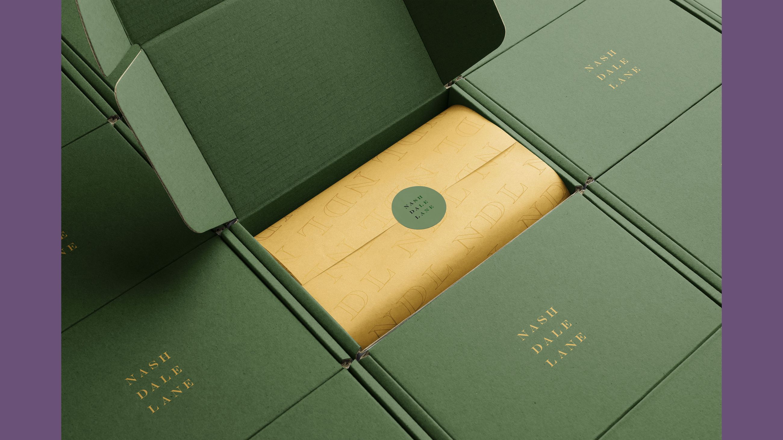 Overhead shot of green boxes with a cream colored package inside, surrounded by more unopened boxes and labels reading Nash Dale Lane.