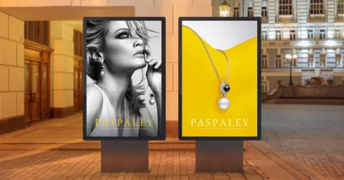 Two digital advertising display screens featuring Paspaley pearl jewellery campaigns mounted on a city street