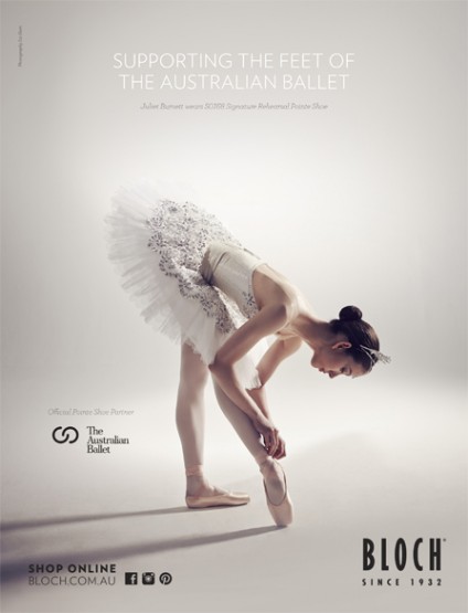 Ballet dancer in white tutu tying pointe shoe, photographed in a photo studio for an Australian Ballet promotional advertisement.