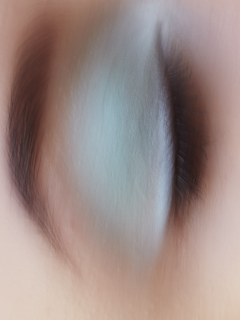 Close-up abstract eye makeup portrait featuring blurred teal eyeshadow and long dark eyelashes by Jen Wilding.