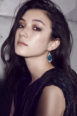 Portrait of a woman wearing a dark pleated top and teardrop earrings, with makeup by Sarah Tammer in Sydney