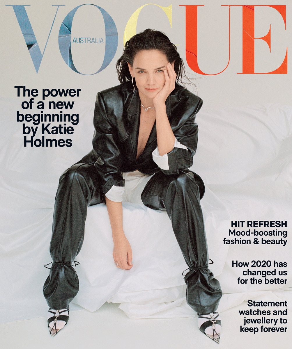 Katie Holmes seated on a white bed wearing a black leather suit with make-up by Linda Jefferyes