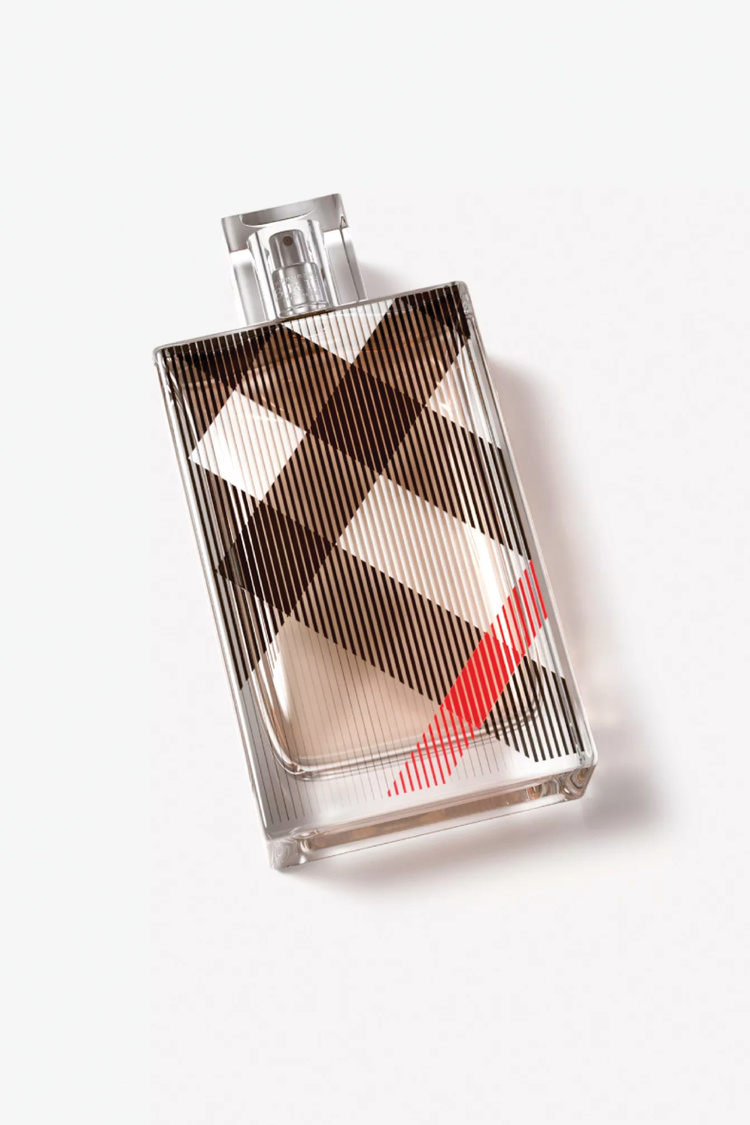 Rectangular Burberry Brit perfume bottle with tan liquid inside, set against a white backdrop in a well-lit studio shot.