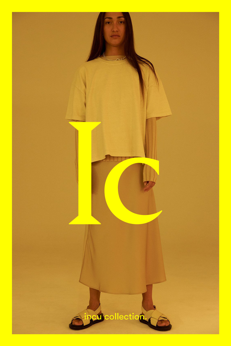 Model standing in cream t-shirt, long skirt, and sandals against a warm yellow gradient background with bold yellow text overlay.