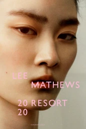 Extreme close up portrait of an East Asian woman with natural skin texture and neutral expression against a plain background