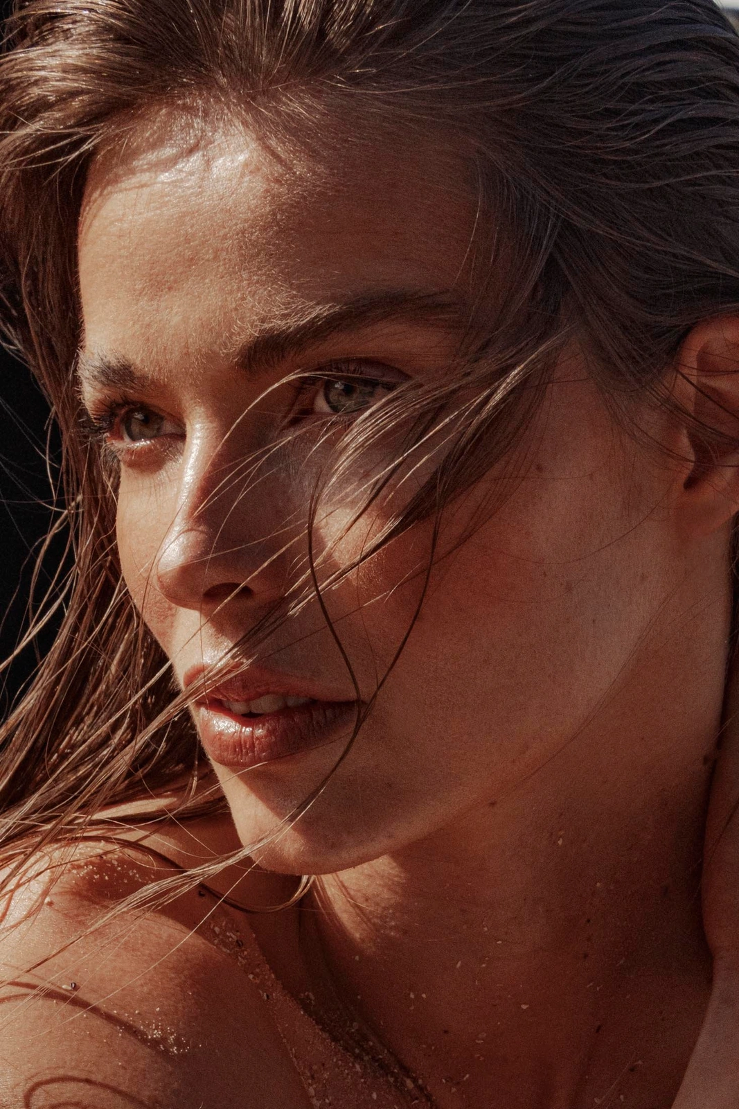 Close-up beauty portrait of a woman with wet hair and warm sunlit skin in Sydney, styled by Max May.