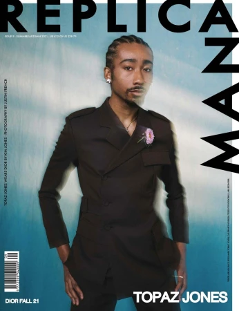 Magazine cover portrait of Topaz Jones wearing a dark double-breasted jacket styled by Melissa Levy against a blue backdrop.