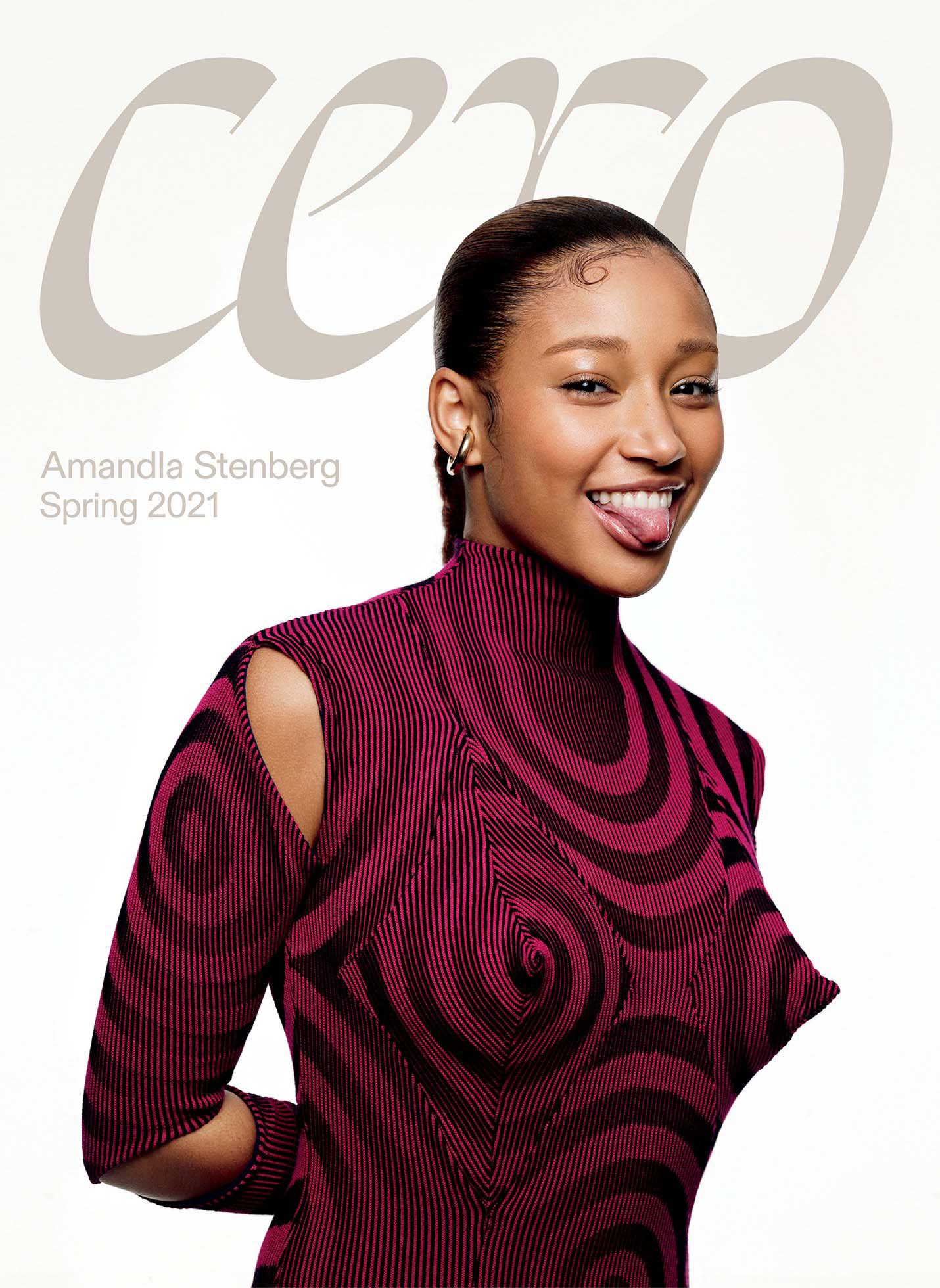 Close-up of Amandla Stenberg on a magazine cover wearing a patterned magenta top, sticking out her tongue, against a white background.