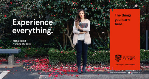 A young woman in a cream vest standing on a tree-lined campus, holding books, beside a banner for The University of Sydney.