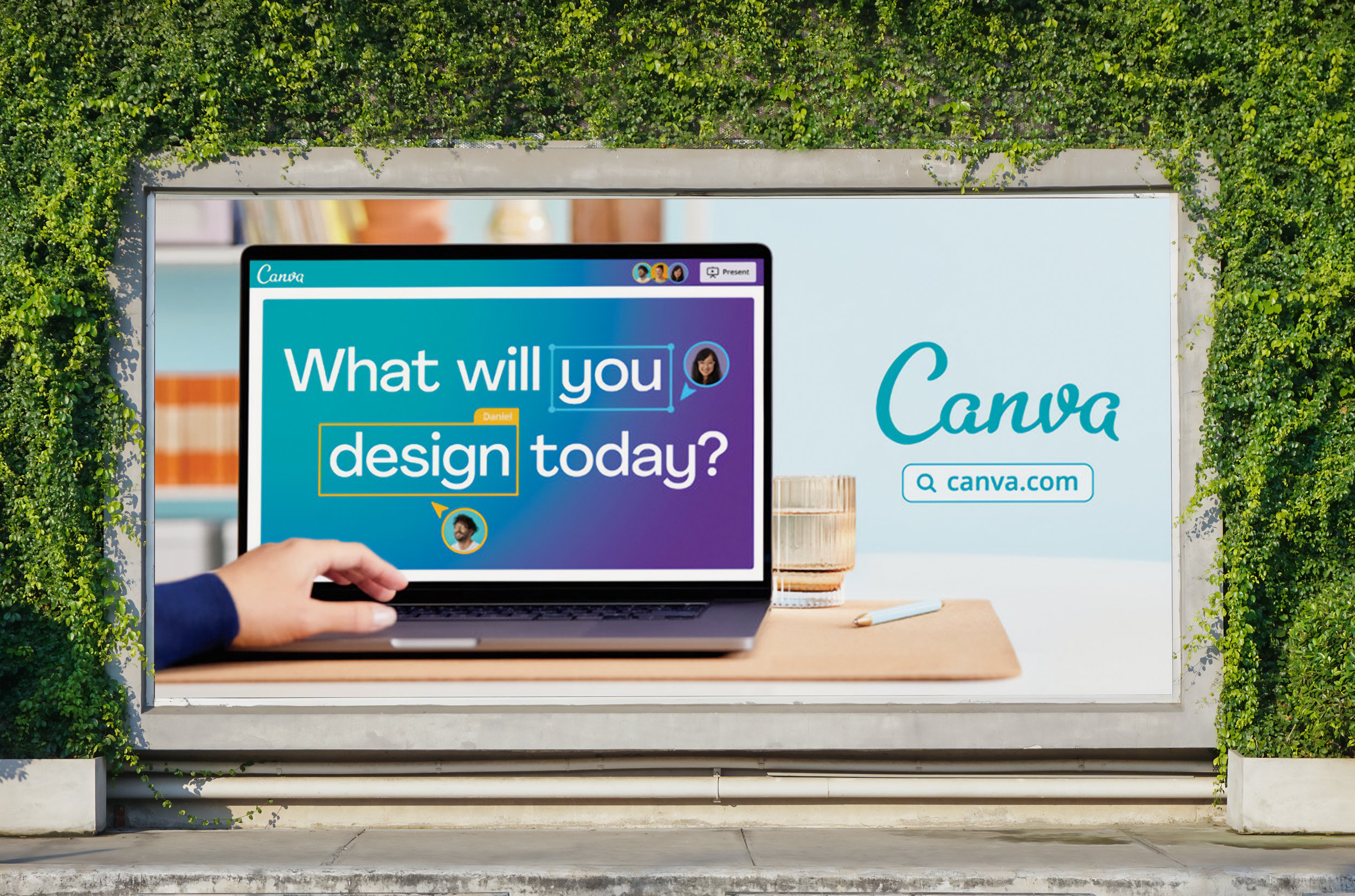 A laptop displaying Canva design software is featured in an outdoor advertisement surrounded by lush green vines, promoting digital creativity.