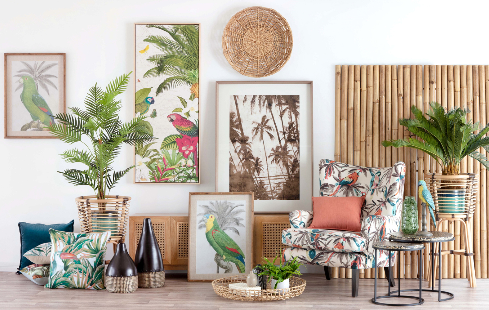 Tropical themed living room decor features parrot prints, rattan accents, palm plants, and cozy patterned armchair on wood floor.