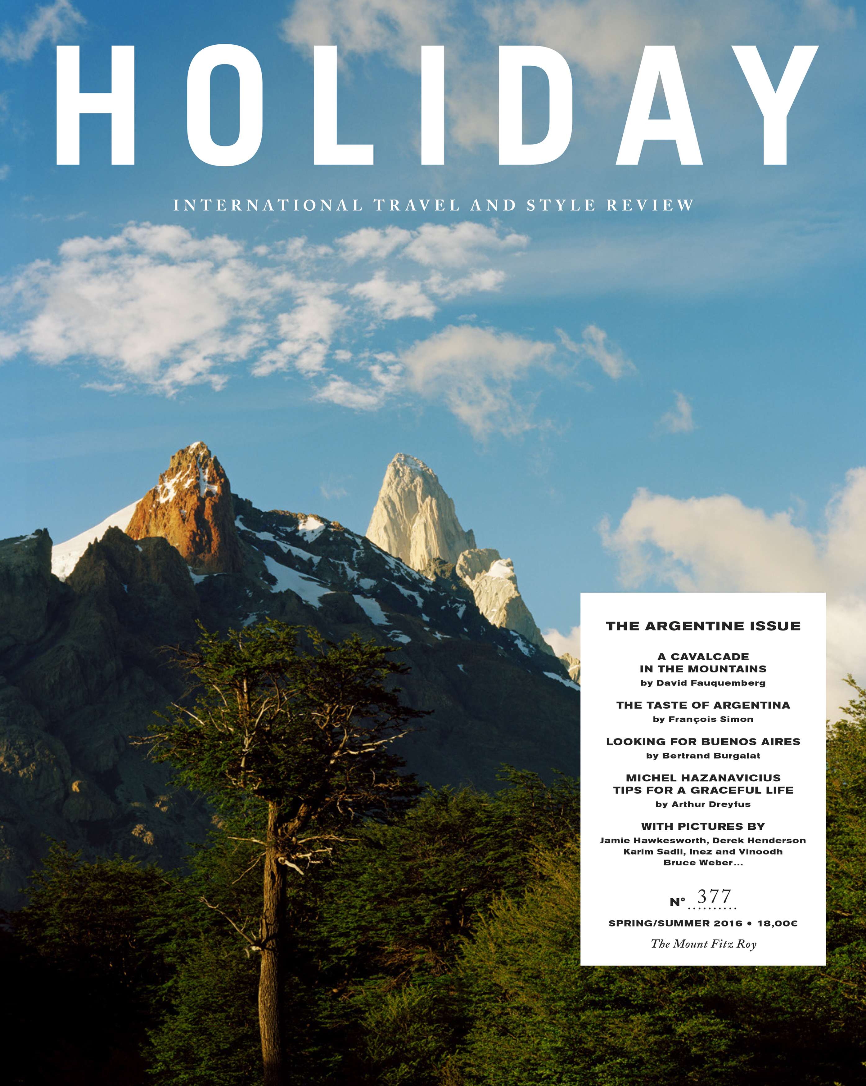 Holiday Magazine cover showcasing a majestic mountain range under a bright blue sky, surrounded by lush green forests. Travel and style publication.