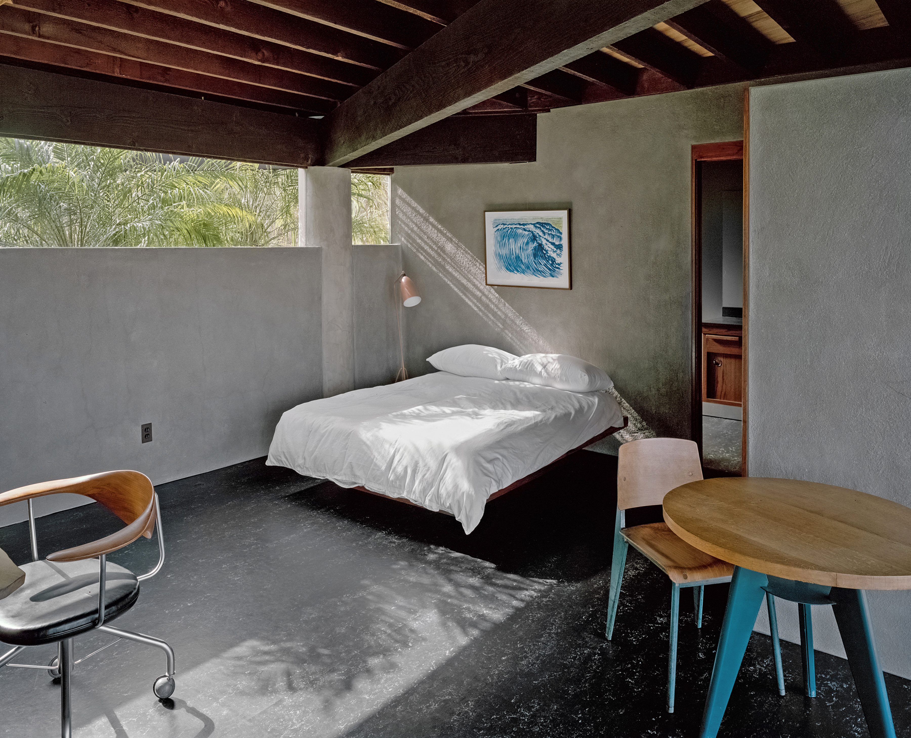 Modern bedroom interior with a white bed, wooden ceiling beams, and minimalist decor, illuminated by natural light, showcasing contemporary design.