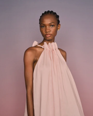 Model in pink halter dress with gathered neckline photographed by Derek Henderson against a gradient background.