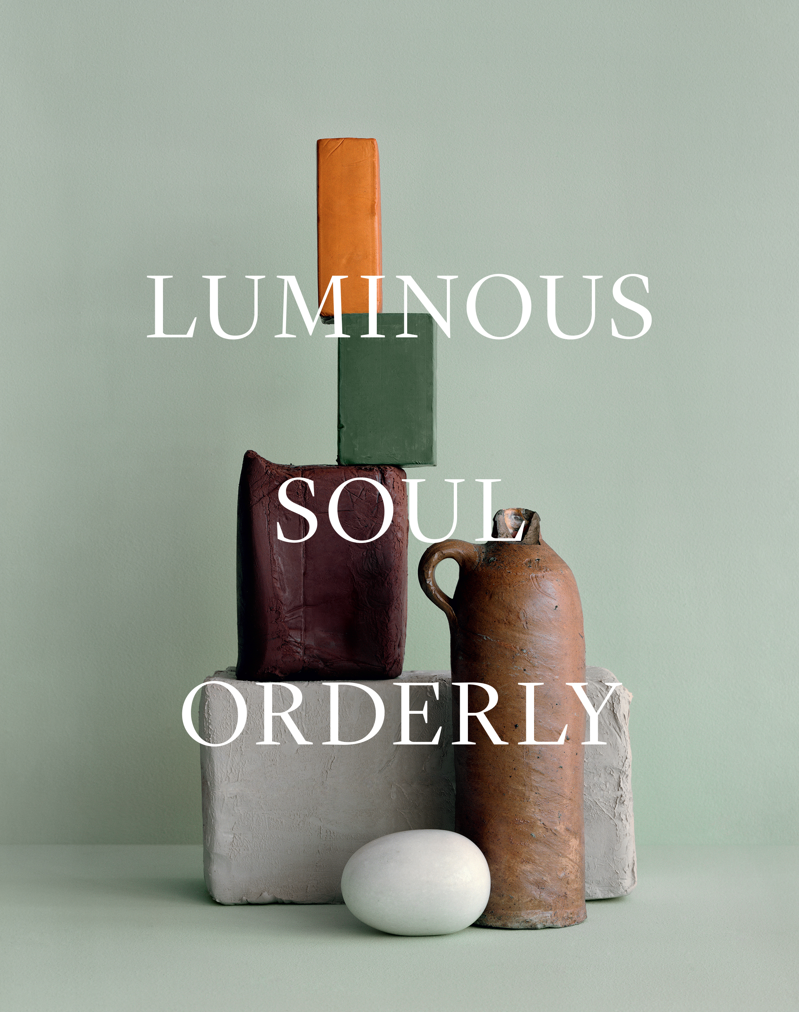 Still life with ceramic objects, arranged in a tower, including blocks, a vase and an egg, against a light green backdrop.