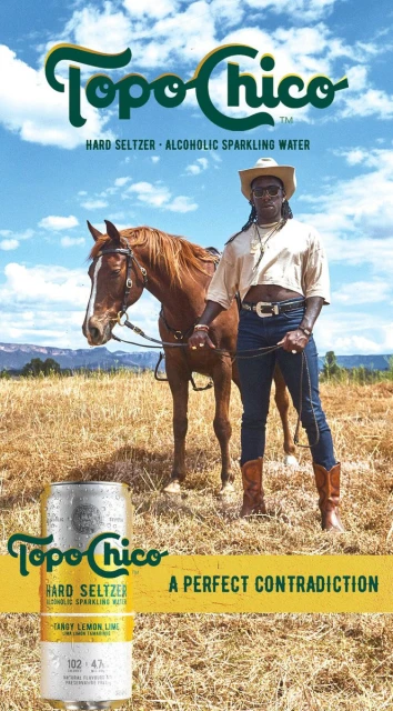 An advertisement for Topo Chico hard seltzer featuring a person in cowboy attire standing next to a brown horse in a field.