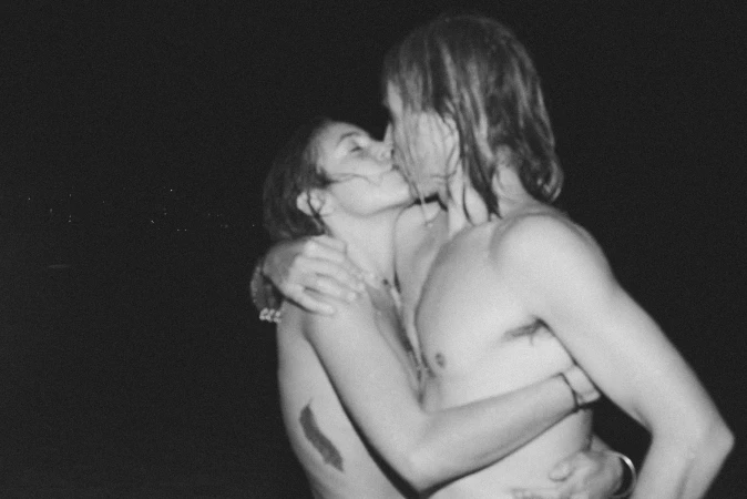 Black and white portrait of a couple embracing and kissing outdoors at night by photographer Tim Swallow in Sydney.