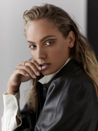 Close up portrait of a woman with graphic eyeliner and wet look hair wearing a dark leather jacket in Melbourne.