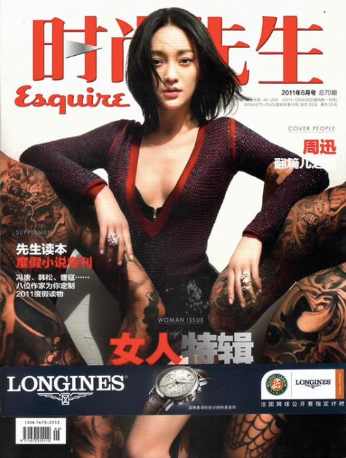 Magazine cover featuring a woman with dark hair and a low-cut top, with tattooed figures in the background and text including Esquire and Longines.