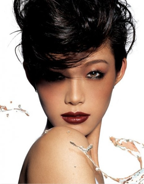 Glamour shot of an Asian woman with dark hair and bold lipstick. Water droplets accent the composition on a bright, seamless backdrop.