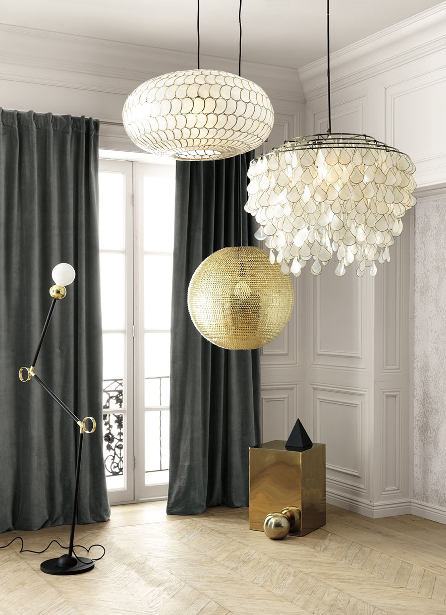 Interior with designer lighting fixtures, a black adjustable floor lamp, grey curtains, and parquet flooring creating a stylish room ambiance.