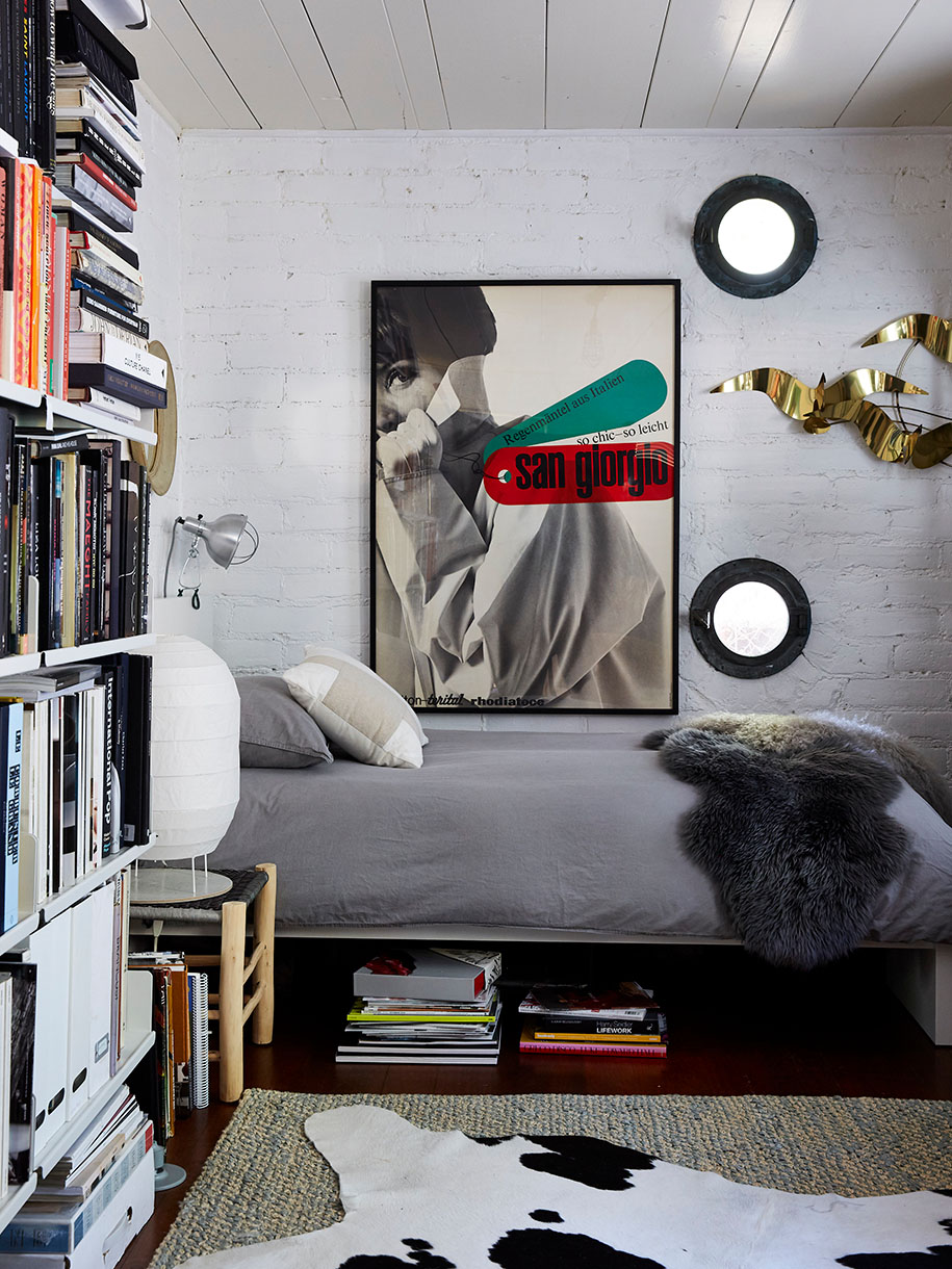 Bedroom interior features a platform bed, gray bedding, cowhide rug, and white bookshelf, creating a cozy and stylish sleep space.