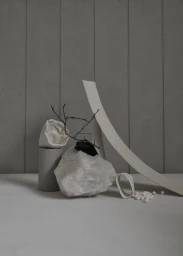 Minimalist still life styling featuring a large raw white crystal, twigs, and sculptural paper elements in Sydney by Lara Hutton