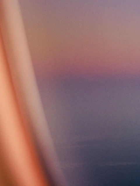 Abstract backdrop featuring a peach column shape against a muted gradient of purple, blue, and pink hues with a blurred effect.