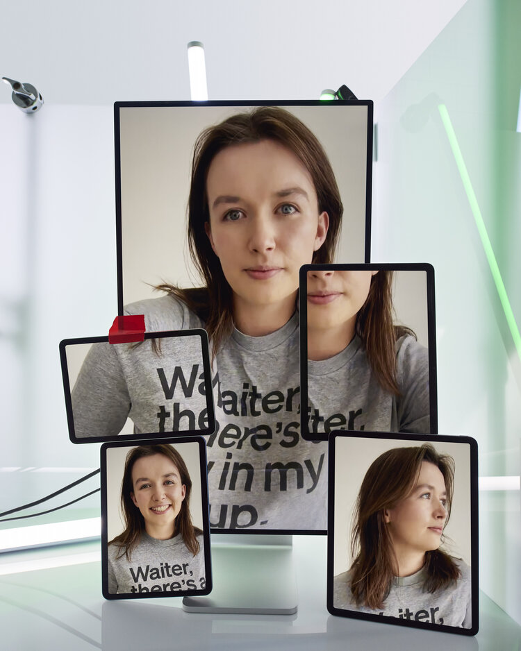 Woman's portrait displayed on multiple screens of varying sizes in a bright, white photo studio with natural-looking lighting.