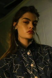 Portrait of a woman wearing a patterned denim jacket and gold earrings shot by photographer Petter Karlstrom.