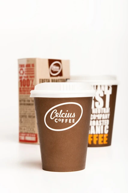 Three Celsius Coffee products: a cardboard box, and two lidded disposable cups, all featuring the Celsius Coffee logo, on white.