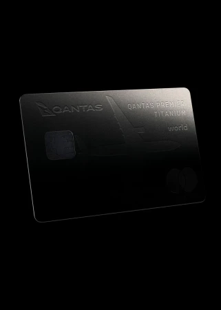 Titanium credit card with the Qantas logo and the word 'world' against a black backdrop, indicating a financial and travel-related product.