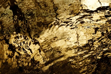 Abstract golden water surface reflections with ripples and shadows captured by photographer Stuart Miller in Sydney
