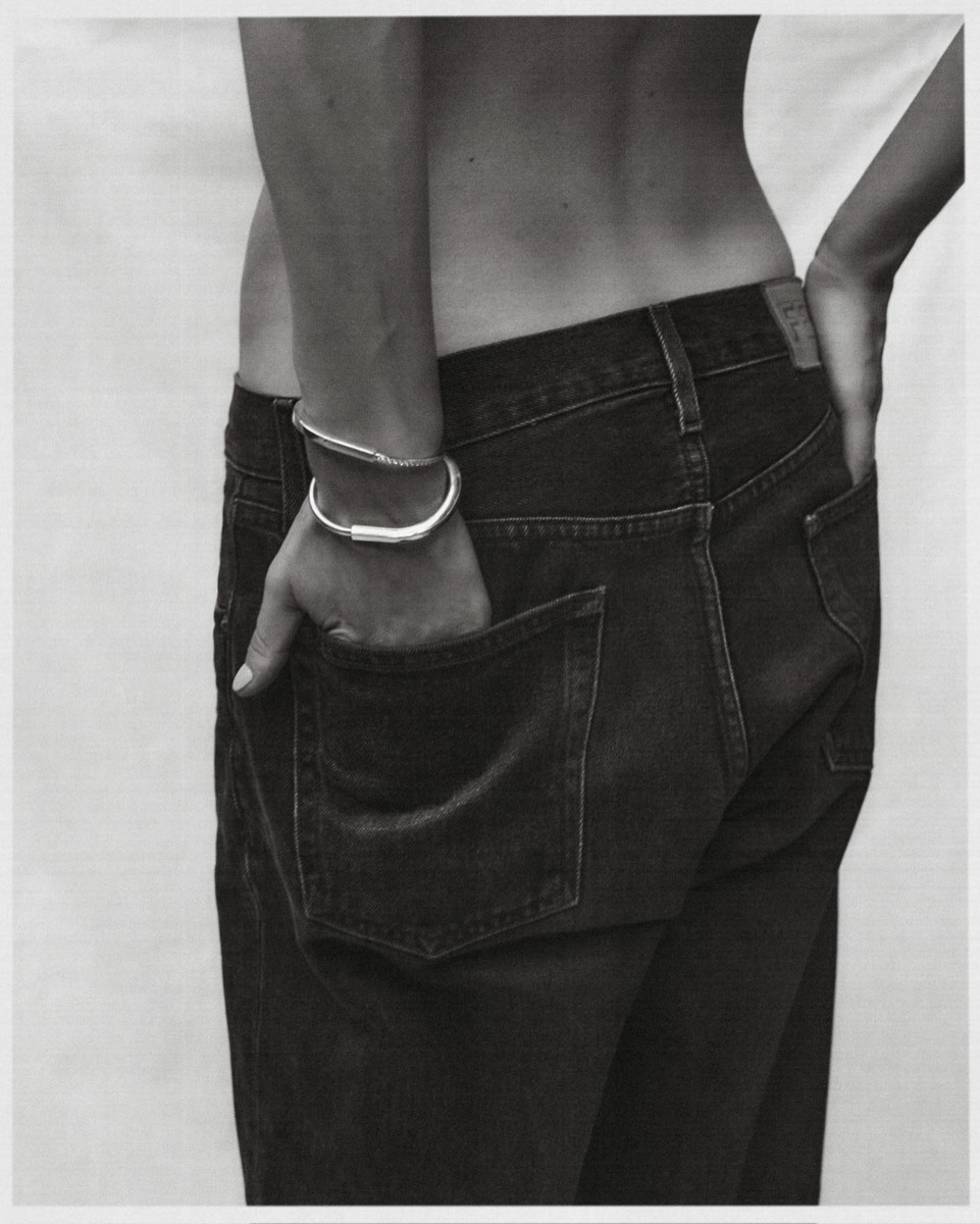 Close-up of a person wearing dark denim jeans and silver bangles, photographed by Darren Mcdonald in Sydney.