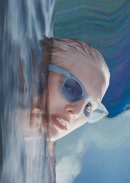 Woman in water with sunglasses and an artistic effect applied, resulting in a surreal and visually striking composition.