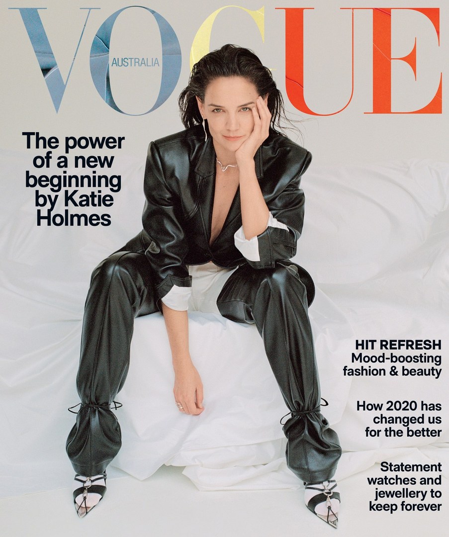 Vogue Australia magazine cover featuring Katie Holmes wearing a black leather suit, sitting on a white bed with a neutral studio backdrop.