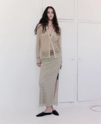 Model with long dark hair wearing a sheer mesh cardigan and matching midi skirt styled by Ria Kamat Shetty