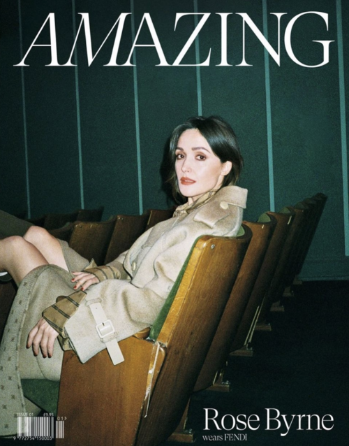 Rose Byrne, magazine cover, seated, wearing Fendi trench coat with dark hair, red lipstick, in an auditorium.