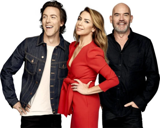 Group photo of three presenters posing in a studio with a white backdrop. One woman is in a red dress, two men are in black tops.