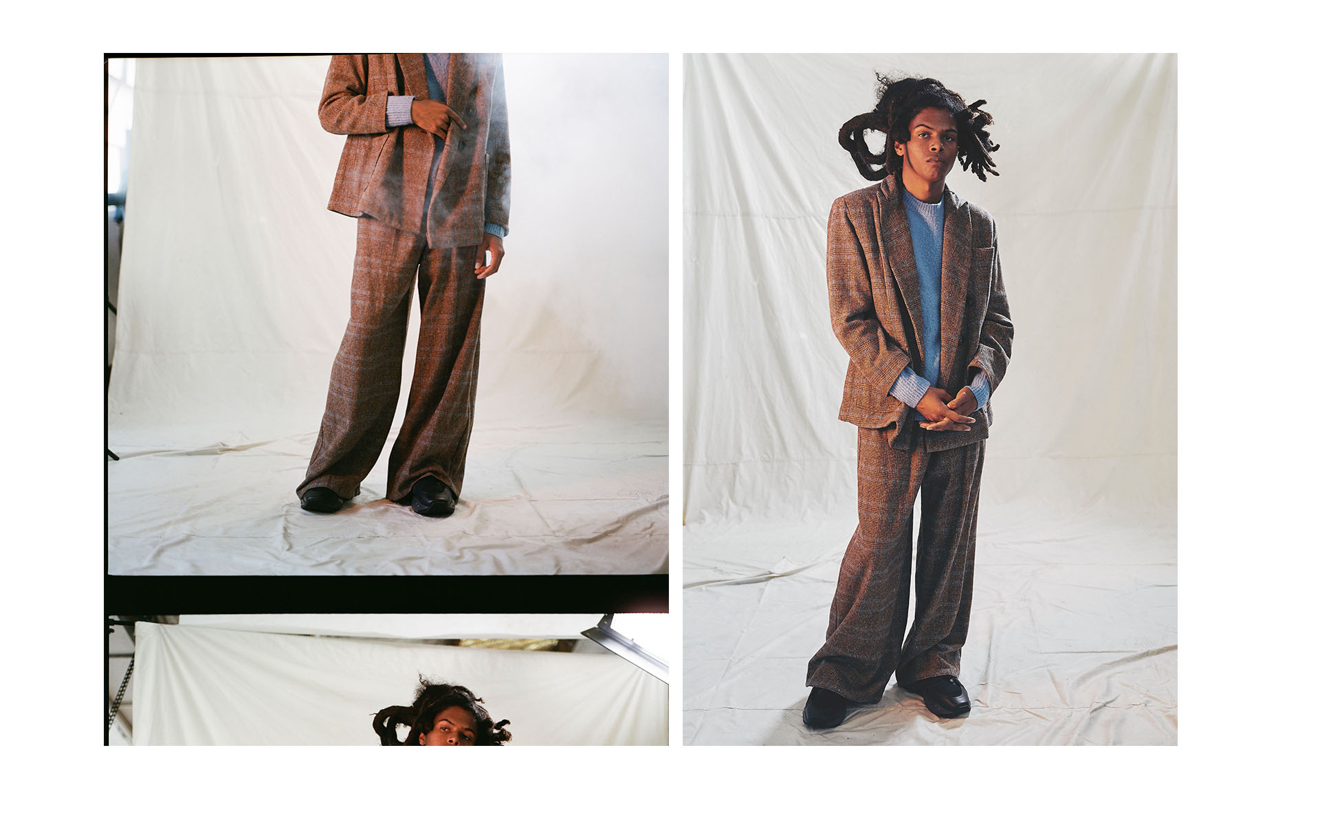 Fashion shot of a young adult in a plaid suit with wide-legged pants against a white backdrop in a photo studio with natural lighting.