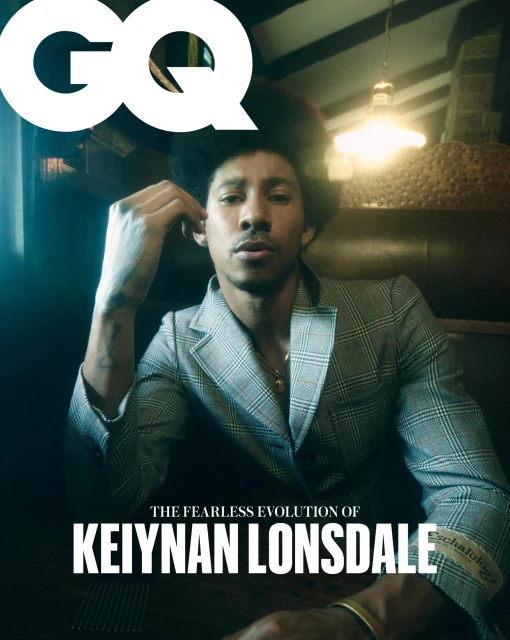 Magazine cover featuring Keiynan Lonsdale in a blazer, inside with warm lighting and shadows, large GQ masthead, typography.
