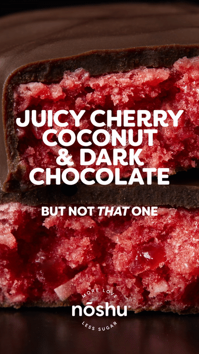 Close-up of a Noshu low-carb cherry and coconut bar, halved to show the texture, with text overlay and product packaging.
