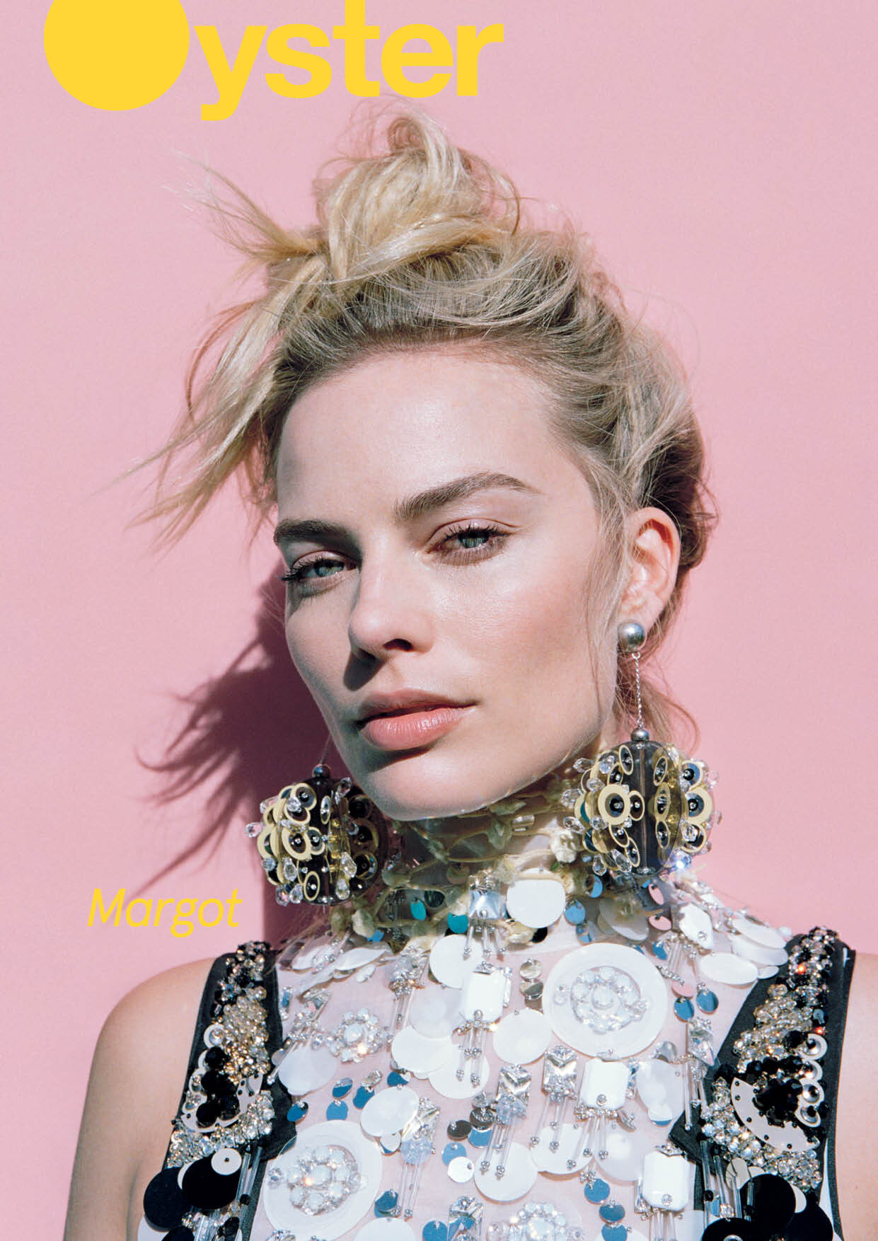 Blonde woman with styled hair and statement earrings poses against pink backdrop for an Oyster magazine cover, portrait orientation.