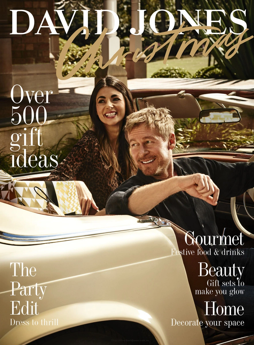 Man and woman smiling inside a vintage cream convertible car with columns in the background, photographed by David Mandelberg