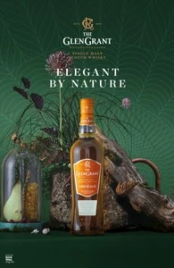 Glen Grant single malt scotch whisky bottle showcased with botanical elements and styled lighting in a product photography setting.
