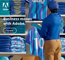 Man in blue uniform places tablet on top of stacks of folded blue and white sports jerseys in a retail store, Adobe logo visible.