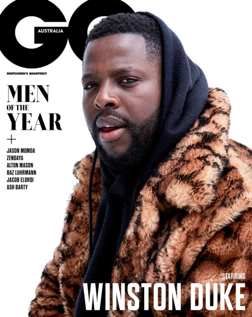Magazine cover featuring Winston Duke wearing a fur coat and hoodie; text includes 'GQ Australia' and 'Men of the Year'.