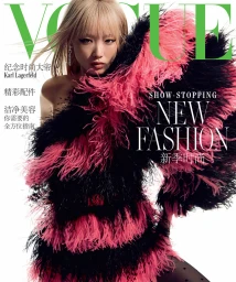 Model in a black and hot pink feathered dress against a white background with Vogue masthead