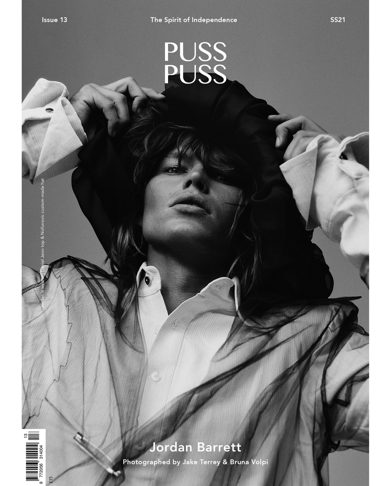 Black and white magazine cover shot of model Jordan Barrett in a sheer top and cap with white collared shirt; "Puss Puss" text visible.