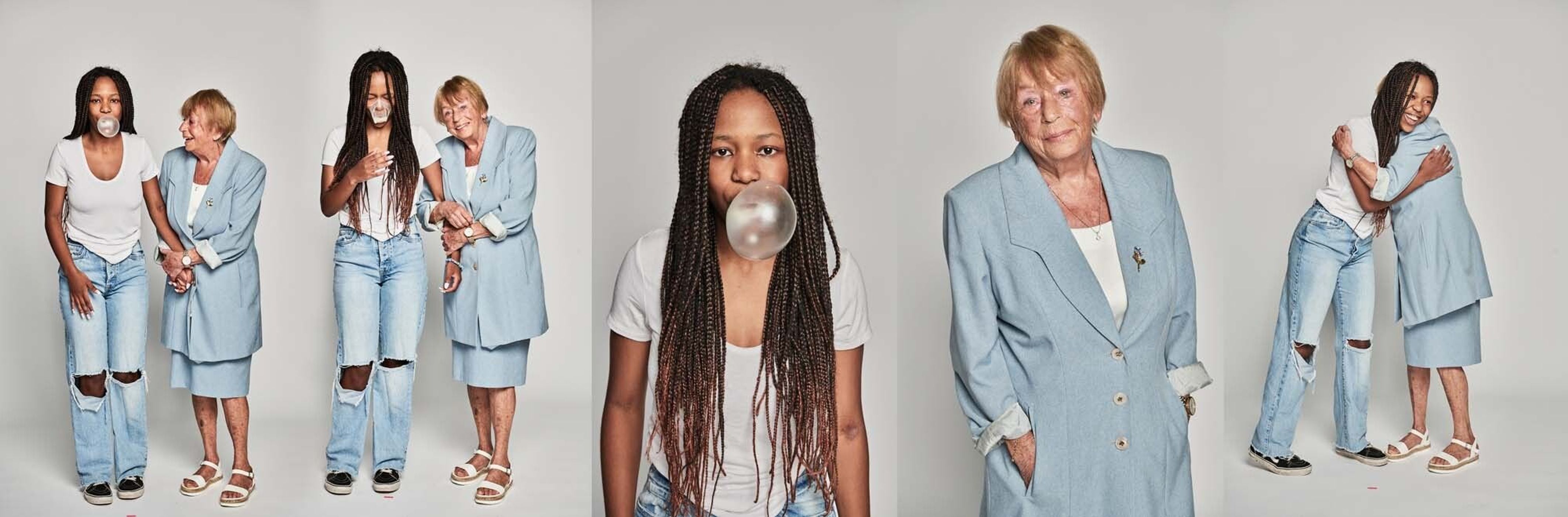Elderly woman and young adult with braided hair pose together; young woman blows bubblegum, set against a neutral studio backdrop.